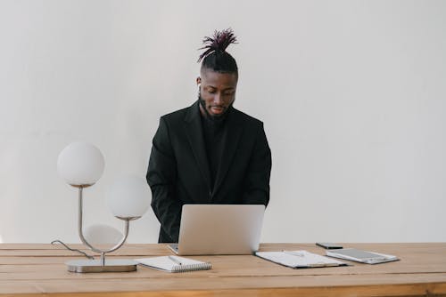 Man in Black Suit Jacket using Laptop