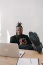 Man in Black Suit with his Legs Up on the Table