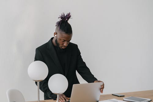 Man in Black Suit Blazer using Laptop