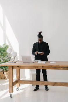 Professional man in business attire working at a desk with modern devices.
