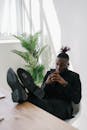 Man using Phone with his Legs Up on the Table