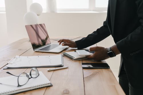 Free Professional workspace with a laptop, documents, and stationery on a wooden table. Stock Photo