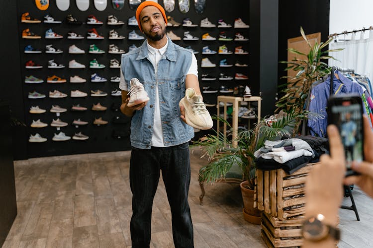 Man Holding A Pair Of Rubber Shoes