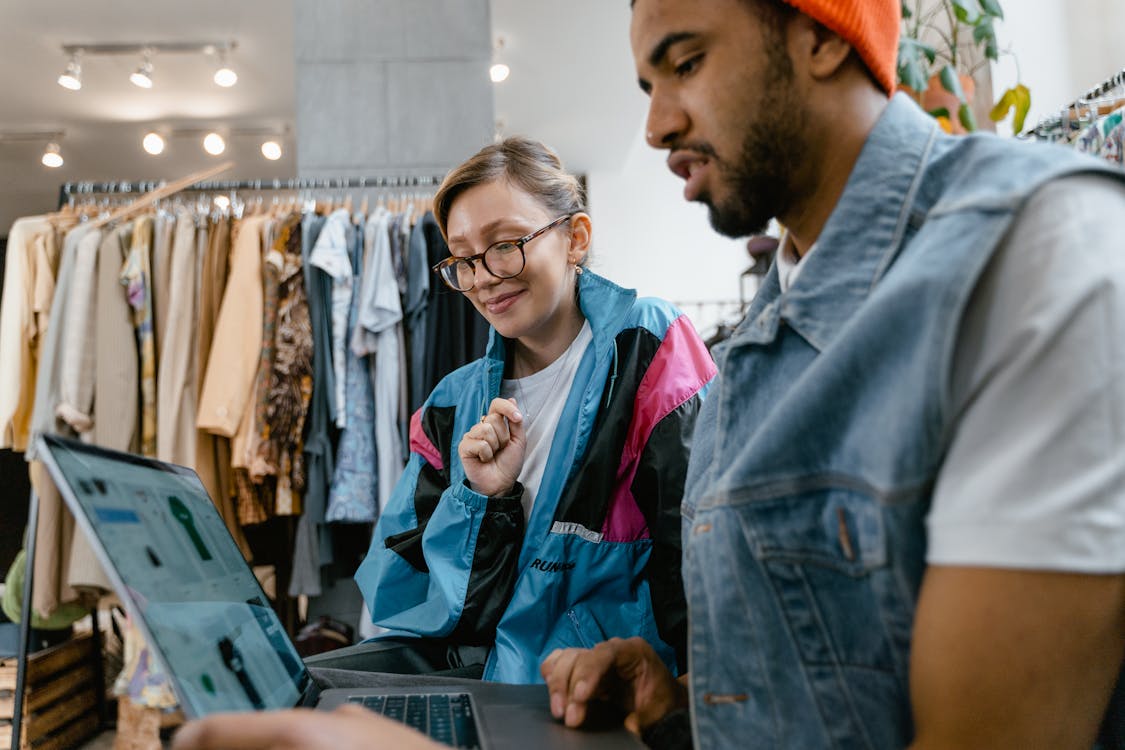 Free A Man and a Woman Looking at A Laptop Screen Stock Photo