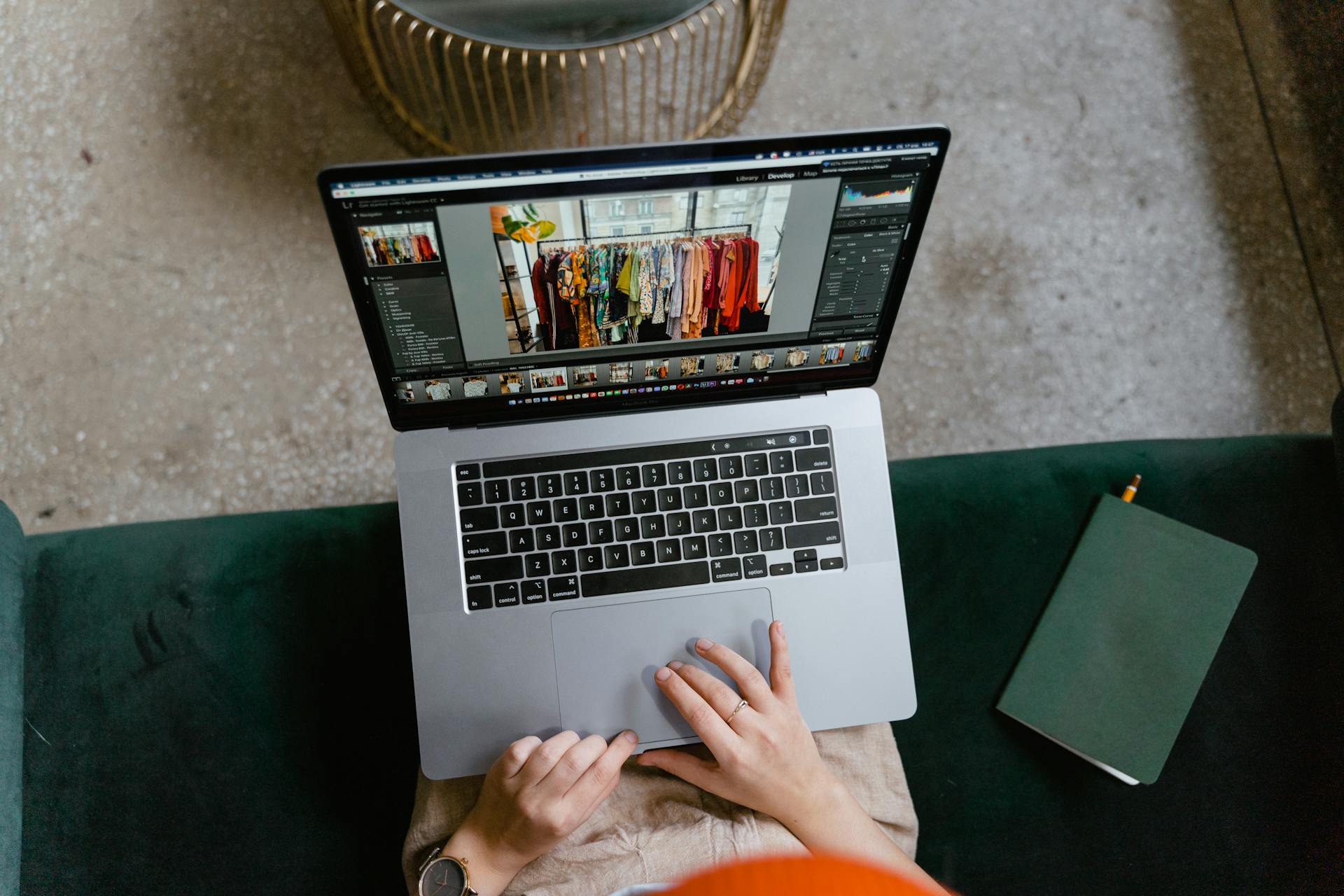 Person editing clothing photos on a laptop indoors, showcasing online fashion business or e-commerce work.