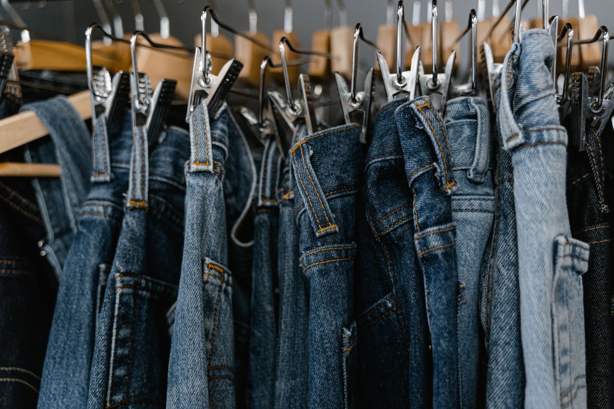 Denim jeans hanging closely packed on a clothing rack