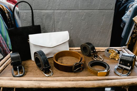 Leather belts and handbags displayed on a wooden rack — MART PRODUCTION on Pexels