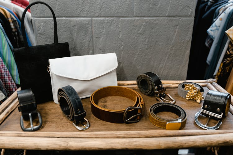 Assorted Black Leather Belts On Brown Wood Table