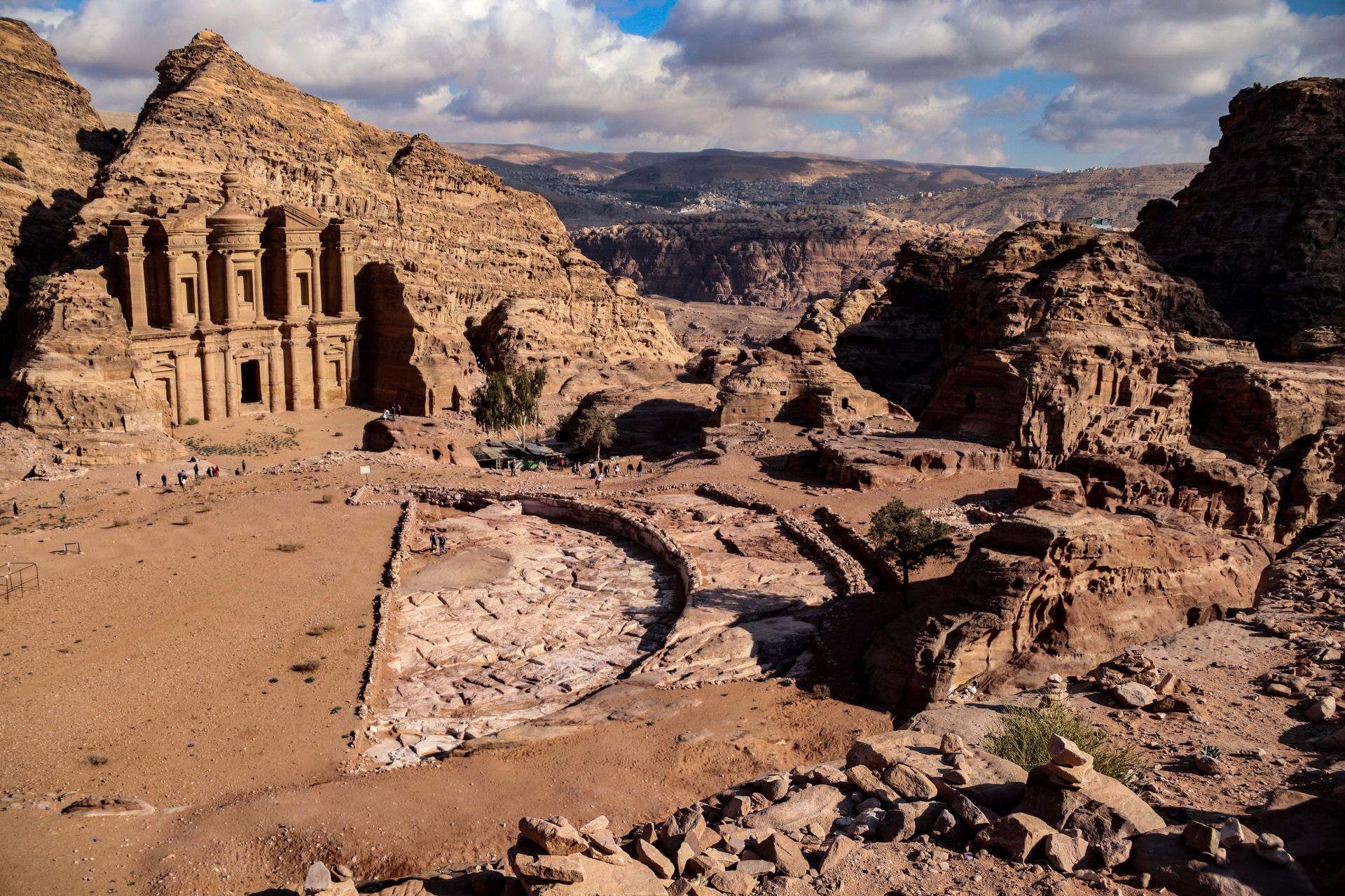 Explore the stunning Ad Deir Monastery in Petra, Jordan, surrounded by rugged desert landscapes.
