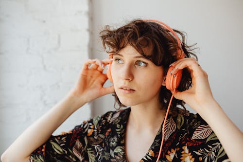 Woman in Floral Shirt Wearing Headphones