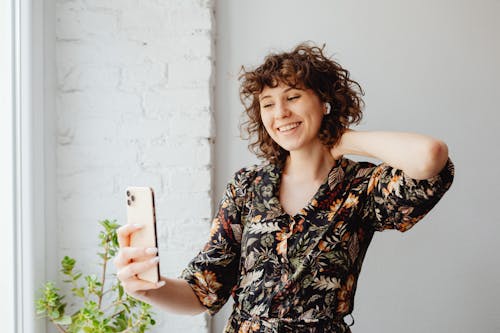 Free Photo of a Beautiful Woman with Curly Hair Taking a Selfie Stock Photo