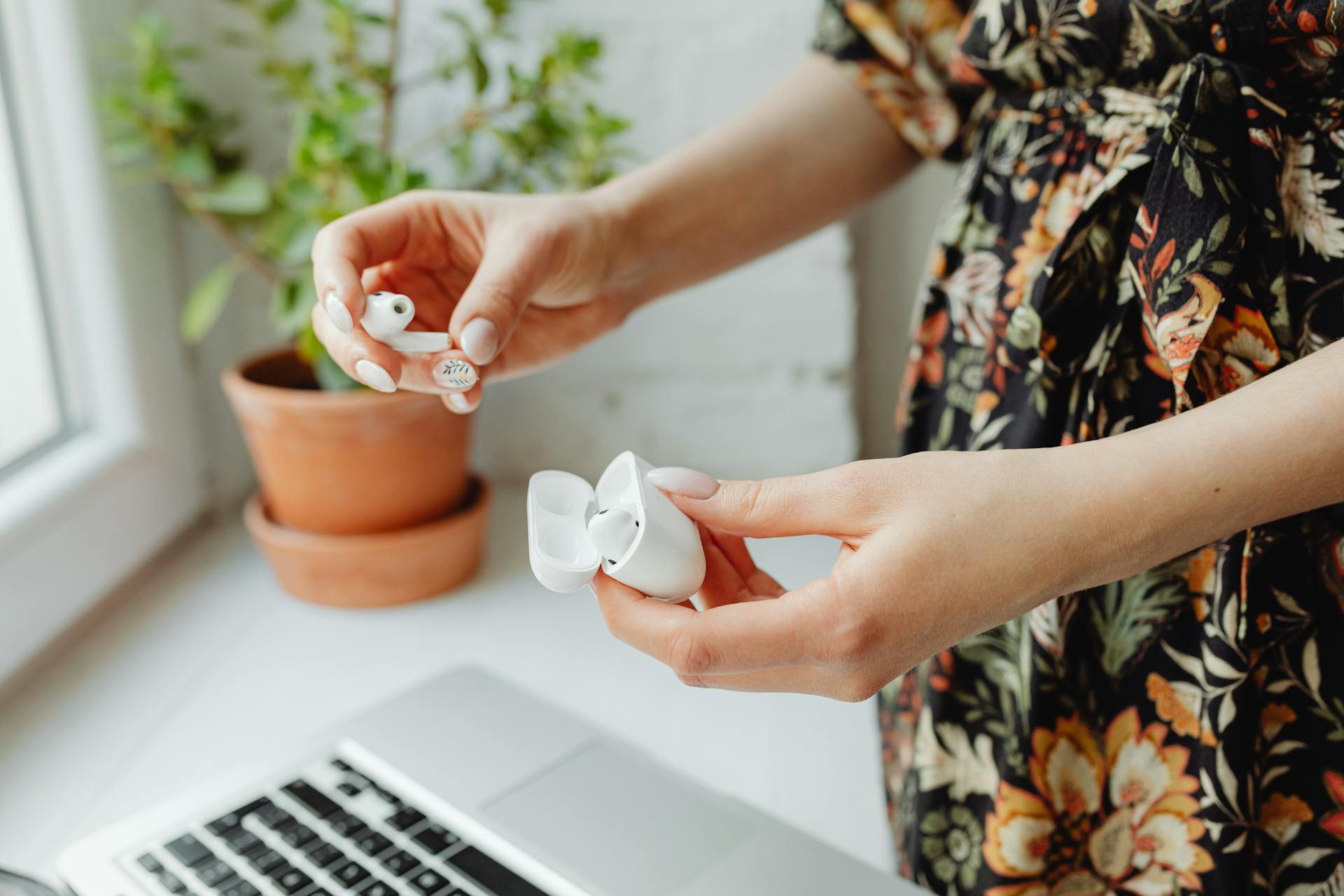 Selective Focus Photo of a Person Putting Airpods in a Case