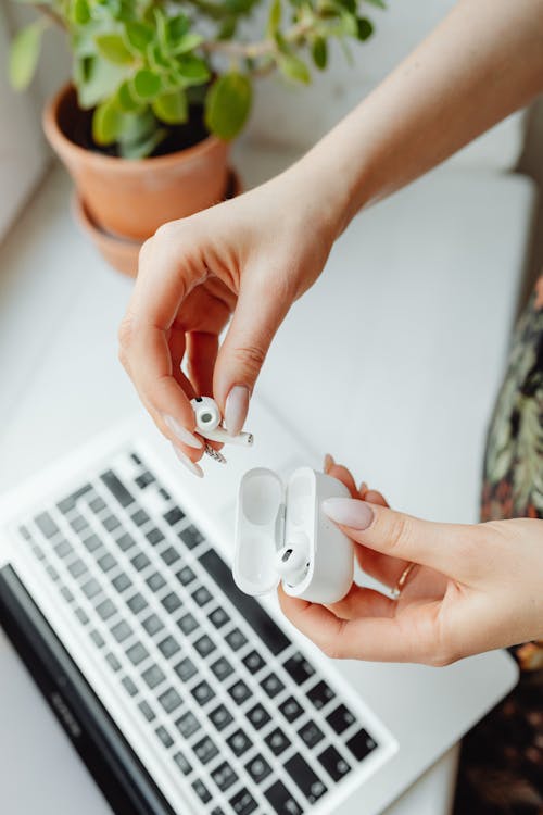 A Person Holding Airpods and Case