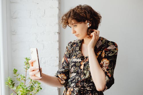 A Woman in Floral Print Dress Holding a Smartphone