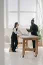 Man in Black Suit Standing by the Table with a Woman