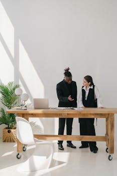 Two professionals engaged in discussion at a sleek office space, showcasing modern business collaboration.