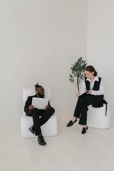 Two colleagues discussing work documents in a bright, modern office setting.