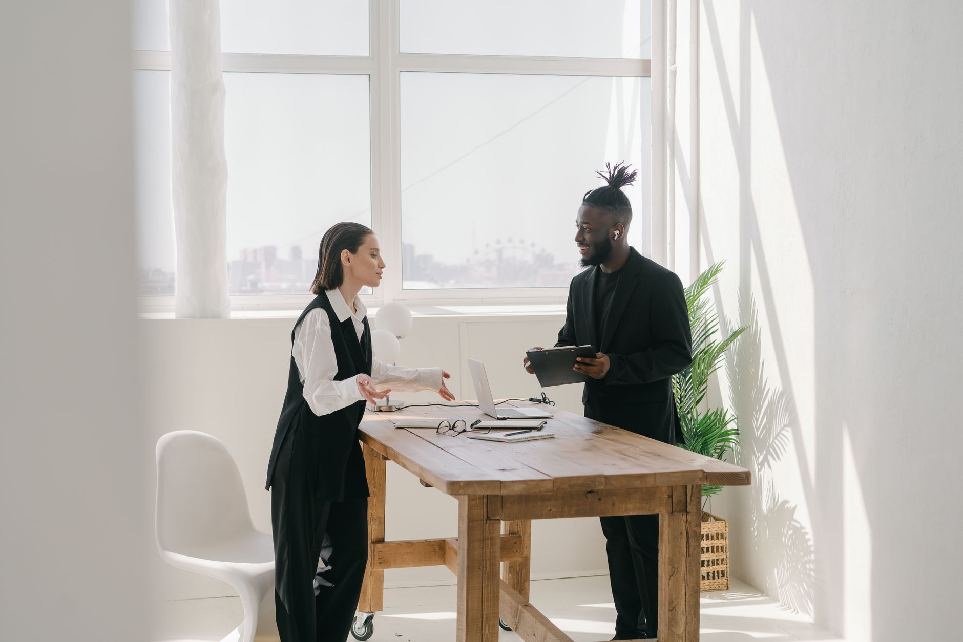 Two professionals talking across a table in a bright office, the shape an executive coaching session takes