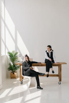 Two business professionals engage in conversation in a bright modern office.