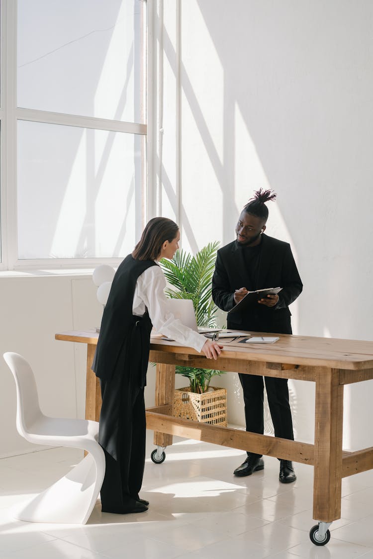 A Man And A Woman In Business Talking Inside An Office