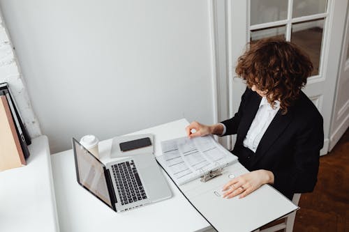 Woman in Black Blazer Checking Documents