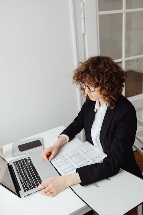 Woman in Black Blazer Holding Using a Silver Laptop 