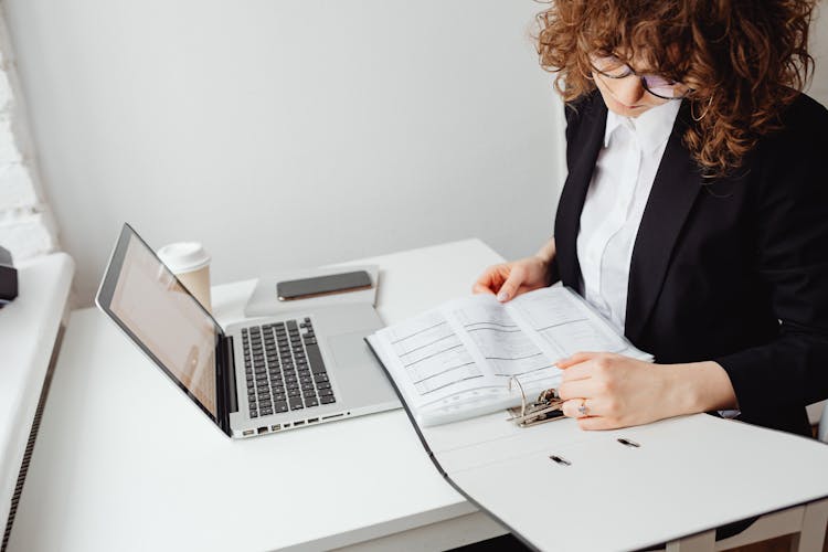 Curly Haired Woman Looking At The Printed Paper 