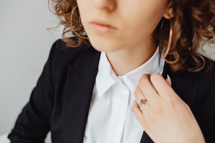 Woman Holding The Peak Lapel Of Her Black Blazer 