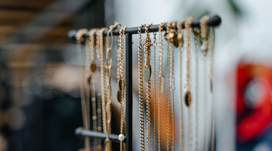 Colliers dorés suspendus sur un présentoir à bijoux