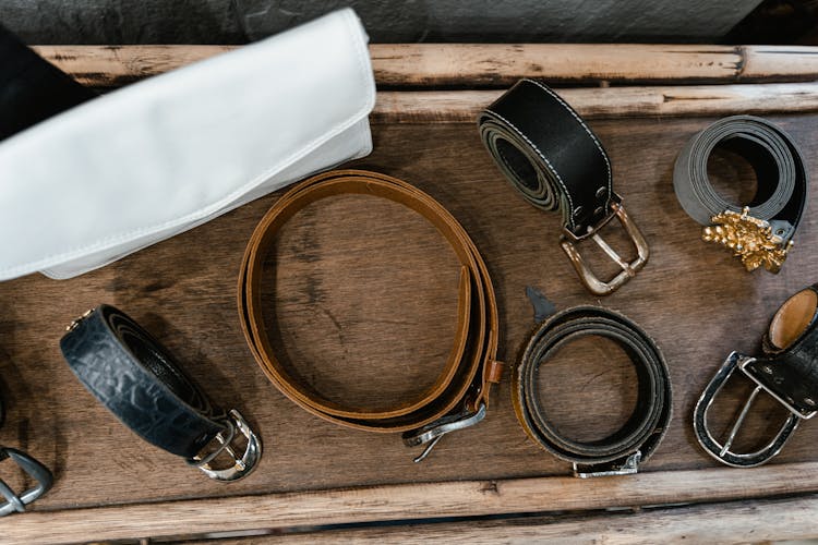 Assorted Leather Belts On Wooden Rack