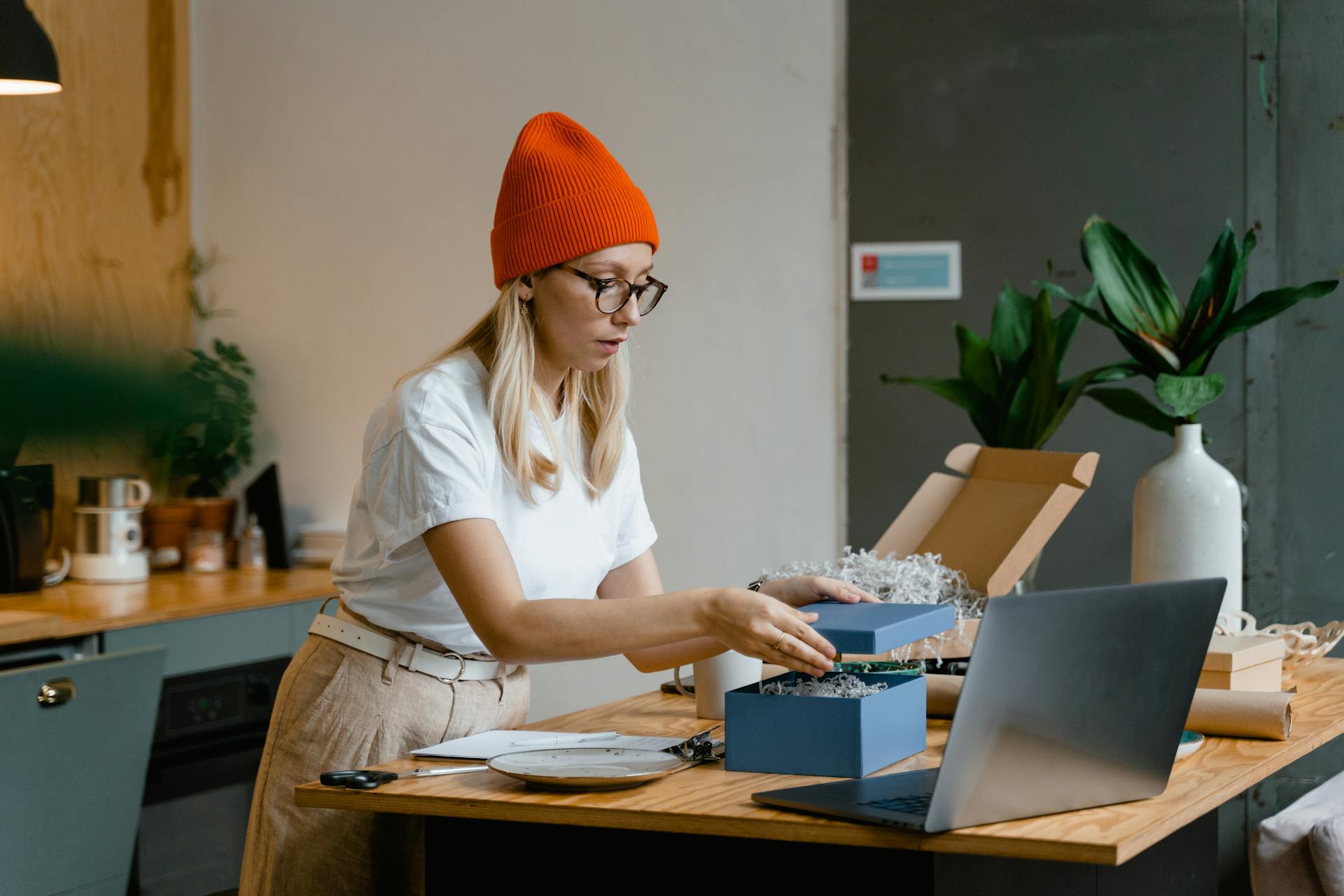A Woman in White Shirt Holding the Lid of a Blue Box