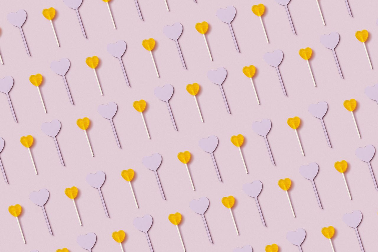 a vibrant pattern of heart shaped lollipops on a pastel pink backgroun