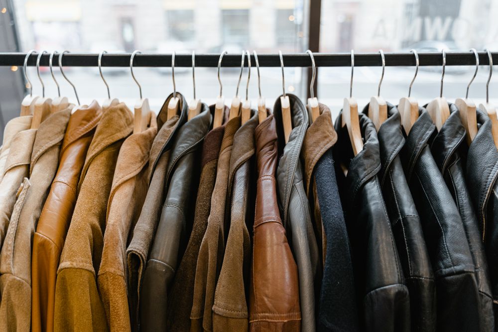Leather and shearling jackets on a rail in the room — photo by MART PRODUCTION on Pexels