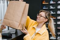 Woman in Yellow Button Up Shirt Holding Brown Paper Bag