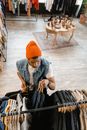 Man in Orange Knit Cap Putting Clothes on the Clothes Rock