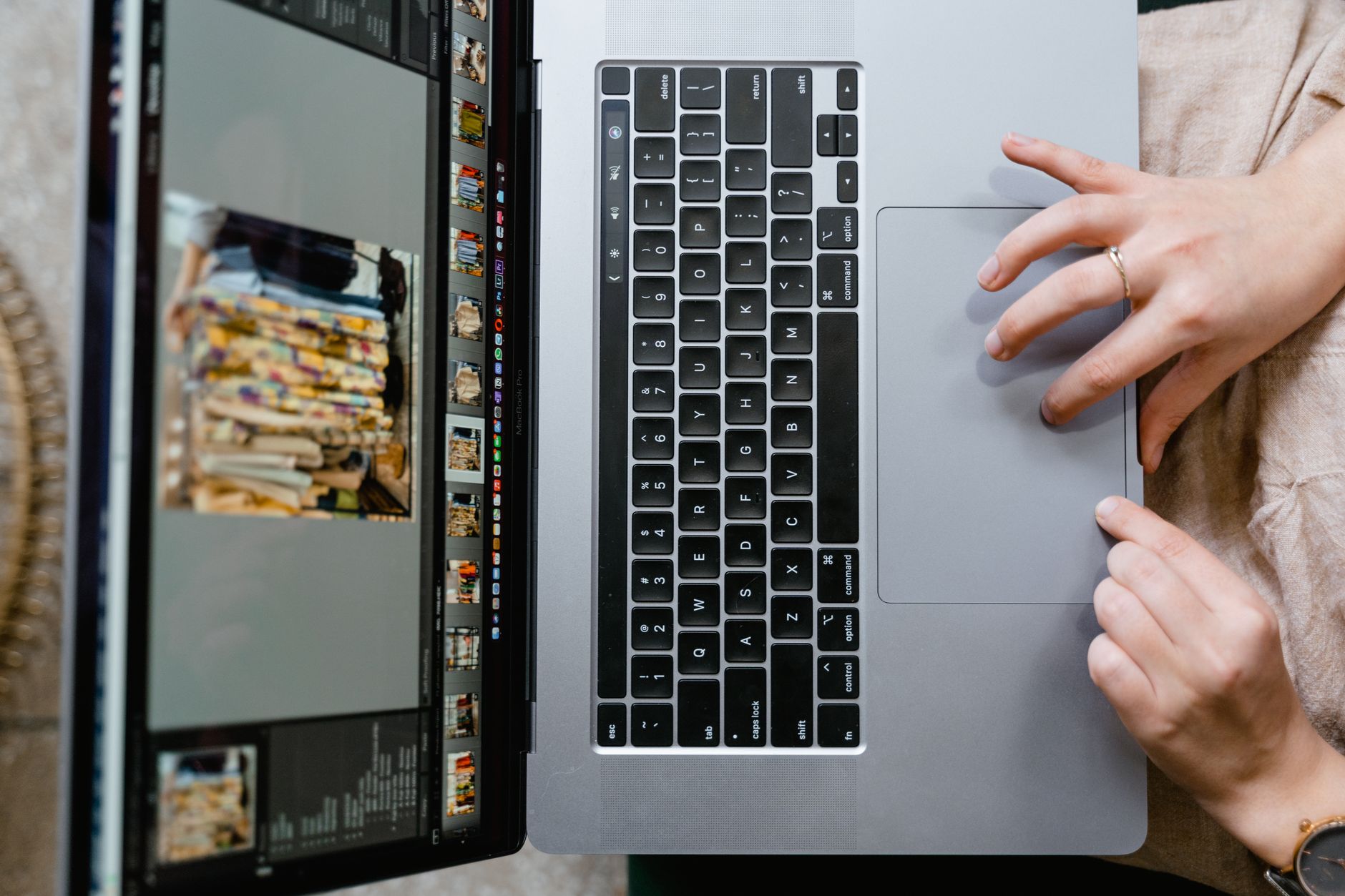 Close-up of hands using a laptop for photo editing, showcasing creativity in digital media.