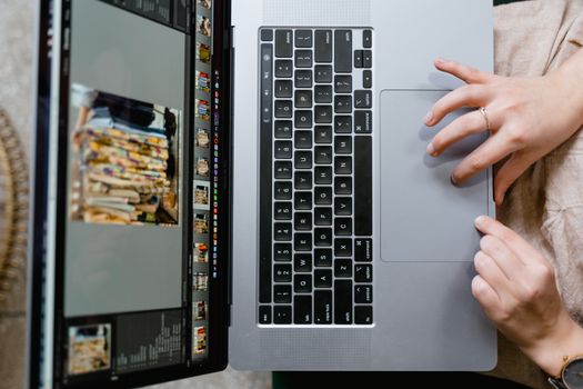 Close-up of hands using a laptop for photo editing, showcasing creativity in digital media.