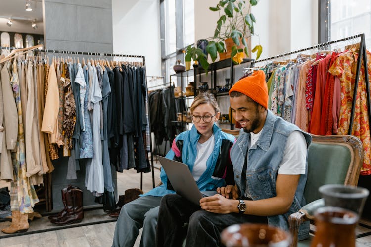 Man And Woman Smiling While Looking At The Laptop 