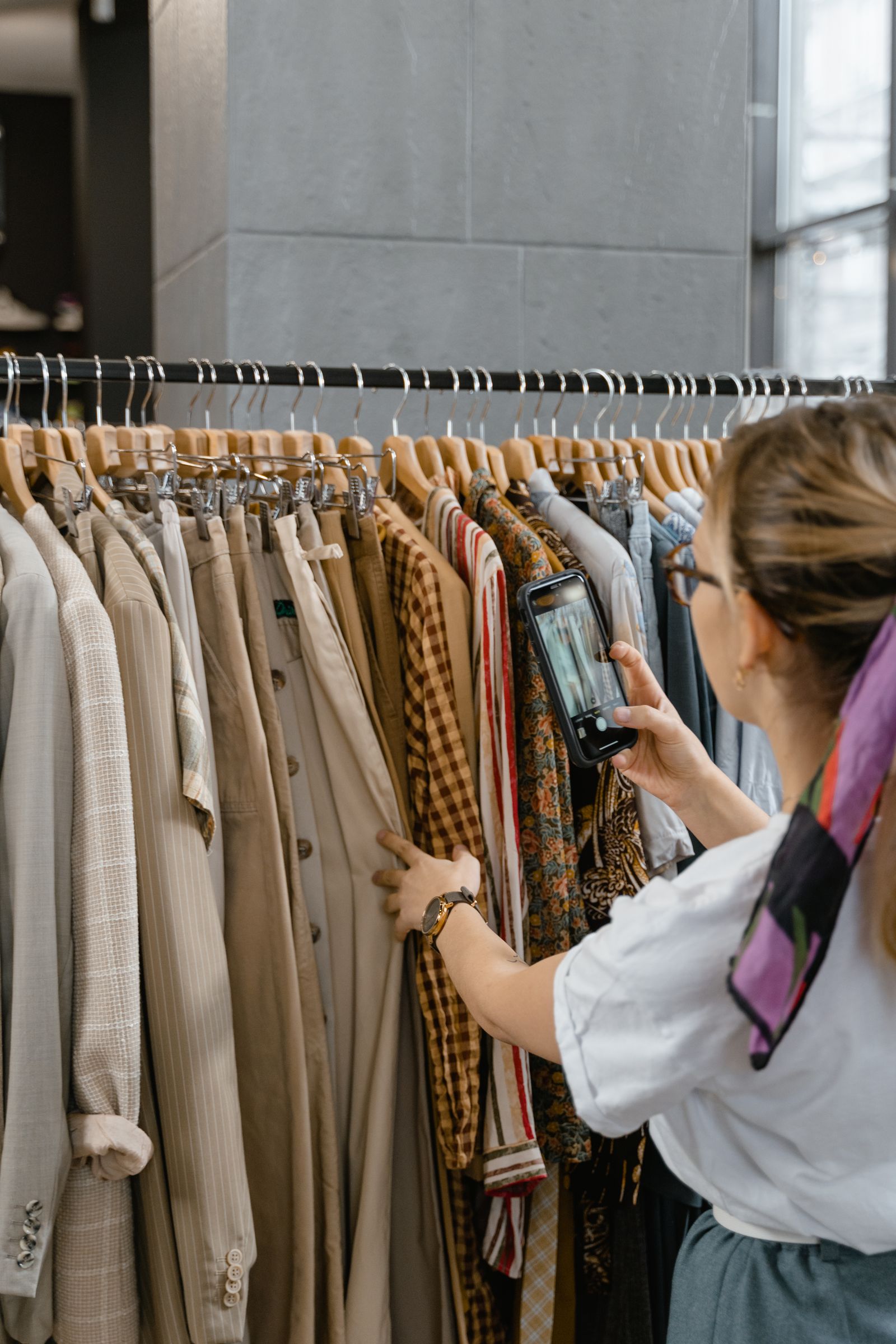 A shopper photographing a fantasy wardrobe in a boutique.