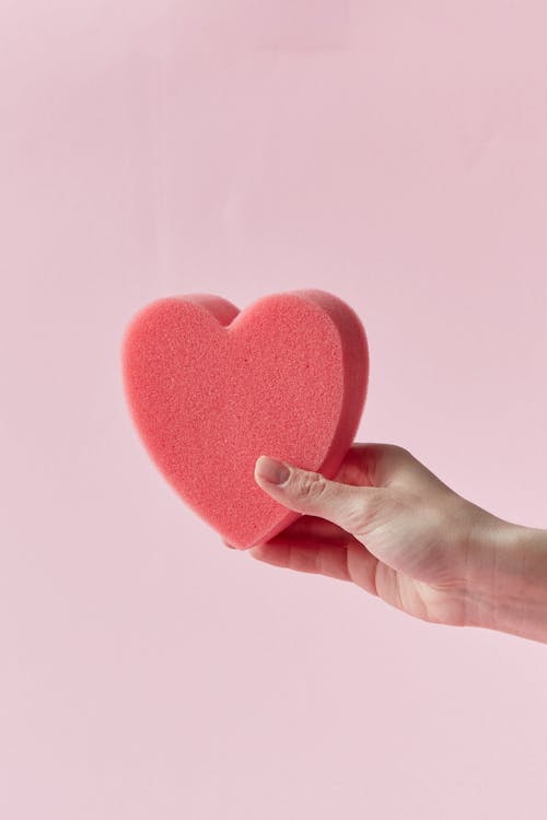 Person Holding a Heart Shaped Sponge 