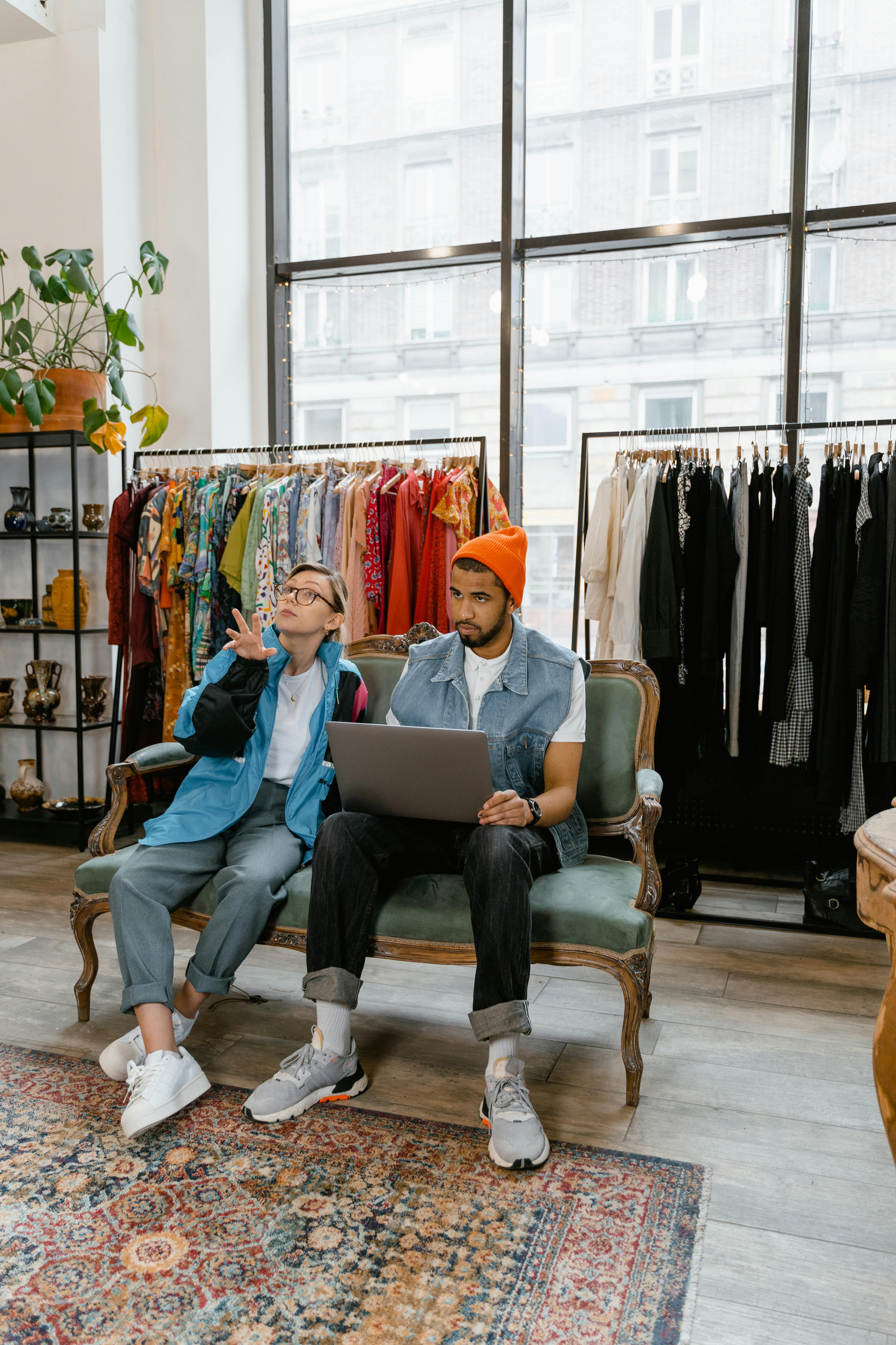 a man and a woman using a laptop while sitting on a couch