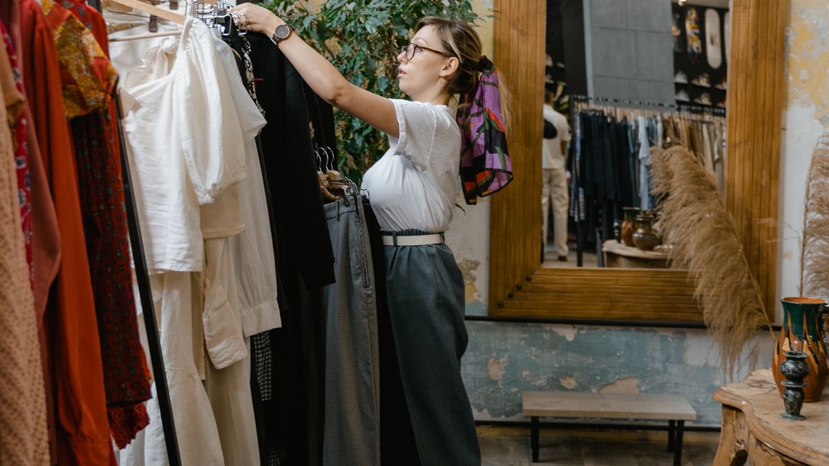 Mujer revisando prendas en una tienda para ilustrar compras en inglés