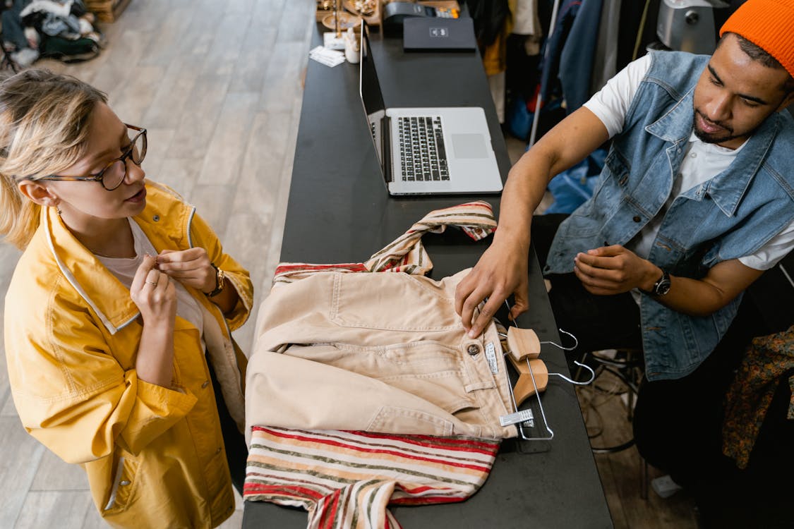 affordable-color-label-printer A woman in a yellow jacket standing in front of a checkout counter while the cashier makes her bill