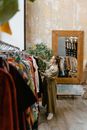 Woman in Brown Coat Standing Near Brown Wooden Cabinet