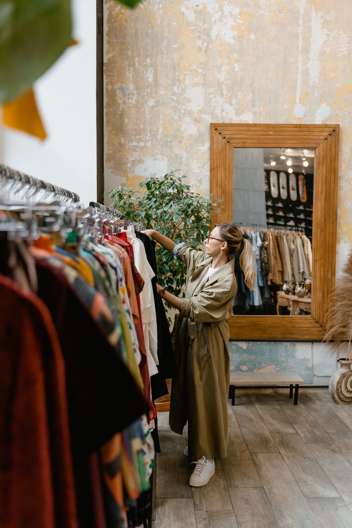 Shopper browsing a clothing rail by a mirror