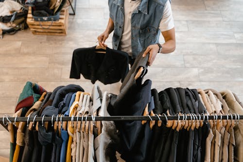 Free Person Replenishing the Clothes Hanging on the Rack  Stock Photo