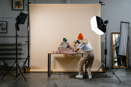 A Woman Taking Photos of the Silverware on the Wooden Table