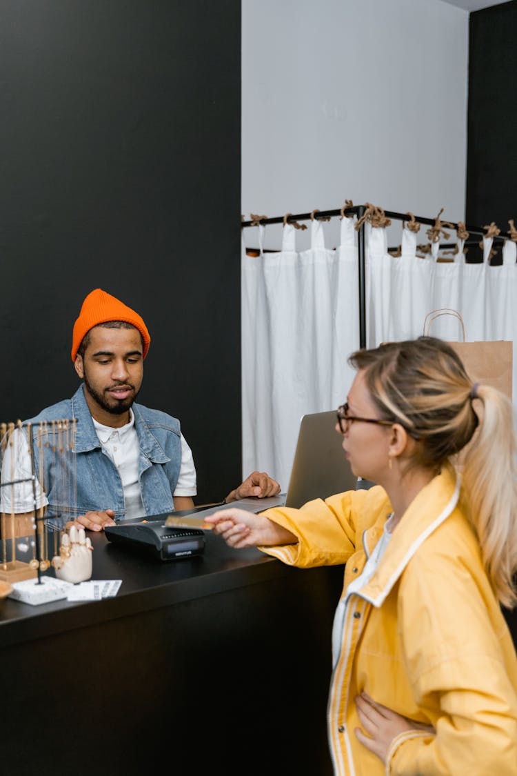 A Woman Swiping The Card On The Payment Terminal In Front Of The Cashier