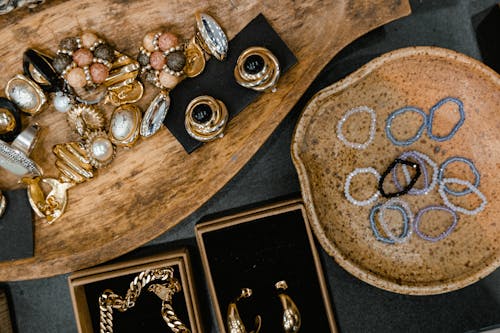 Top View of Handmade Jewelry Lying on Wooden and Ceramic Trays 