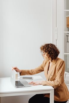Woman in Brown Blazer Sitting at White Table